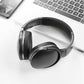 Baseus Encok D02 PRO wireless headphones placed next to a laptop and smartphone for work and music use